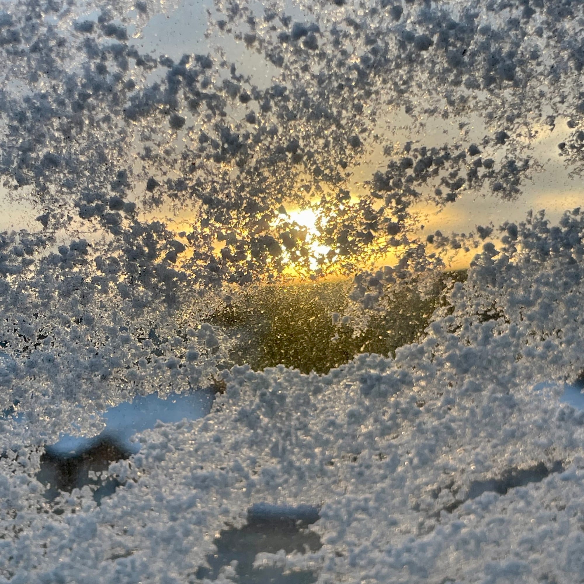 Ein Fenster mit Eisblumen, hindurch scheint die Morgen Sonne