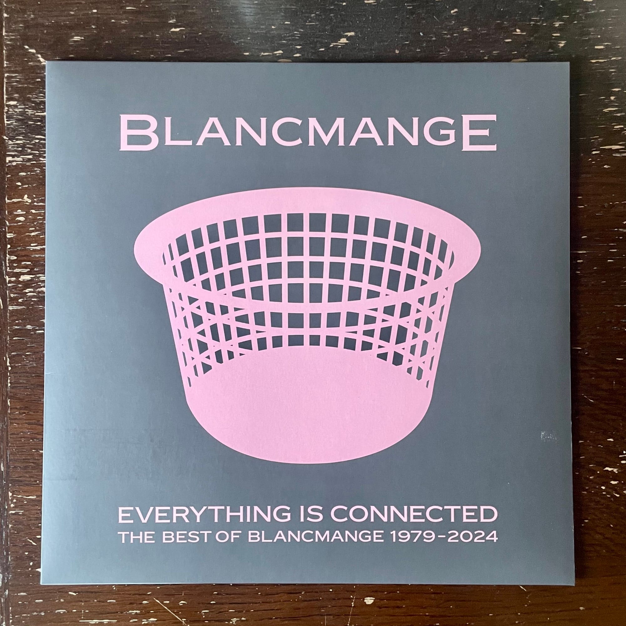 Ein Schallplatten Cover liegt auf einem Holztisch