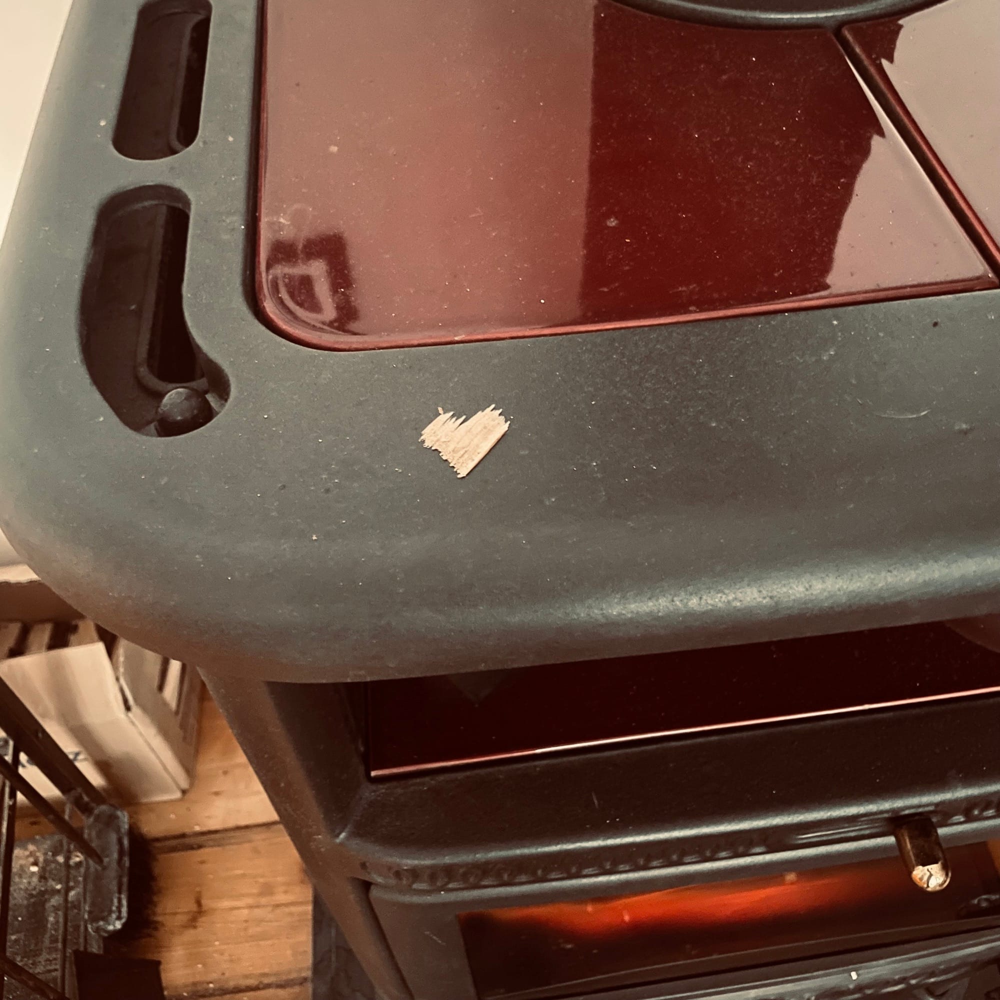 Auf einem Kamin liegt ein kleines Stück Holz, es hat die Form eines Herzens.