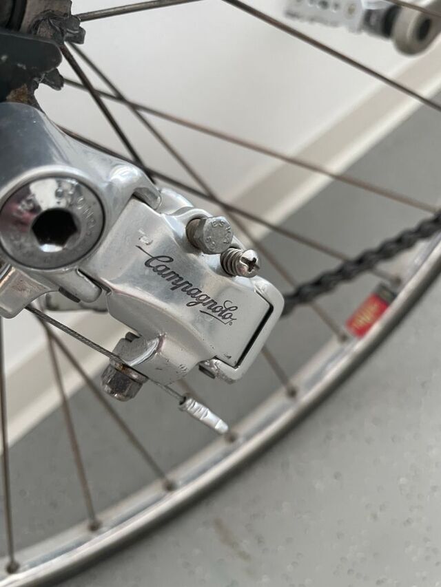 Der hintere Umwerfer eines alten Vintage Rennrades, es ist ein Campagnolo Chorus und man sieht die Speichen vom Hinterrad.